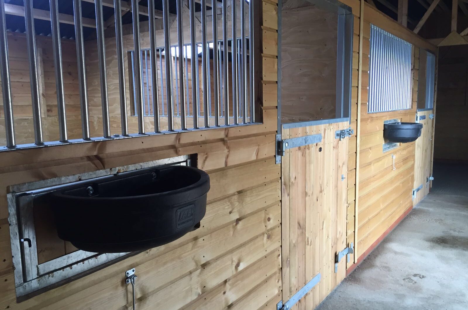 internal stables inside the american barn, swivel feeders face towards the passageway