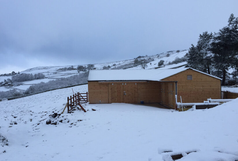 Stables covered in snow on a hillside