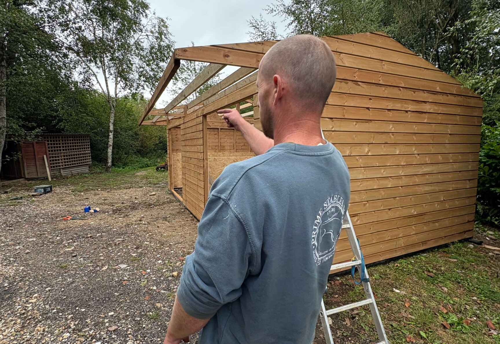 Craftsman pointing at mobile field shelter that is being installed