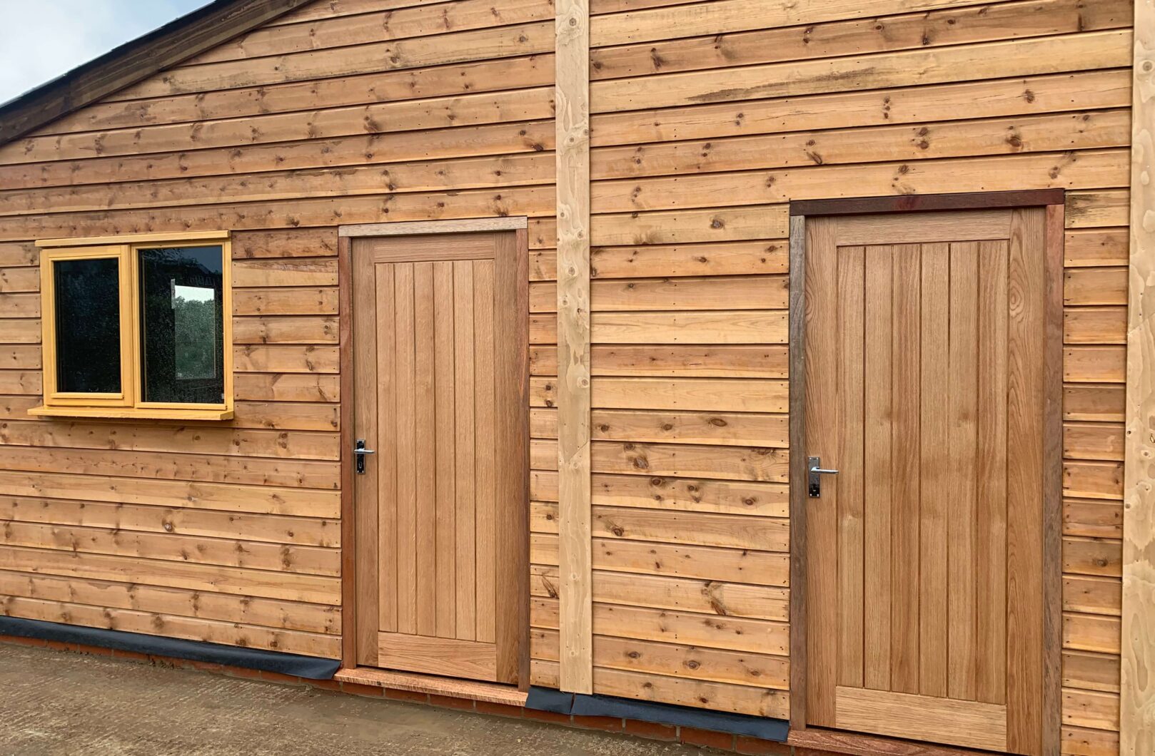 Two personal doors and a casement window on the side of the barn