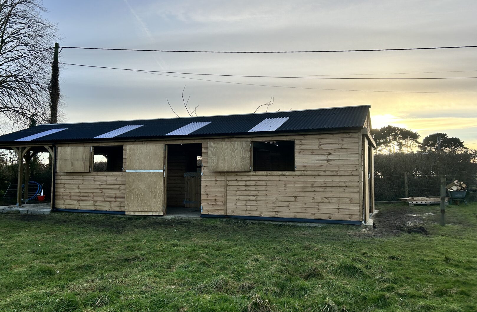 American barn with doors open and sunset in the background
