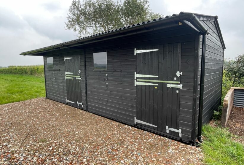 Double mobile stable painted black with top doors closed