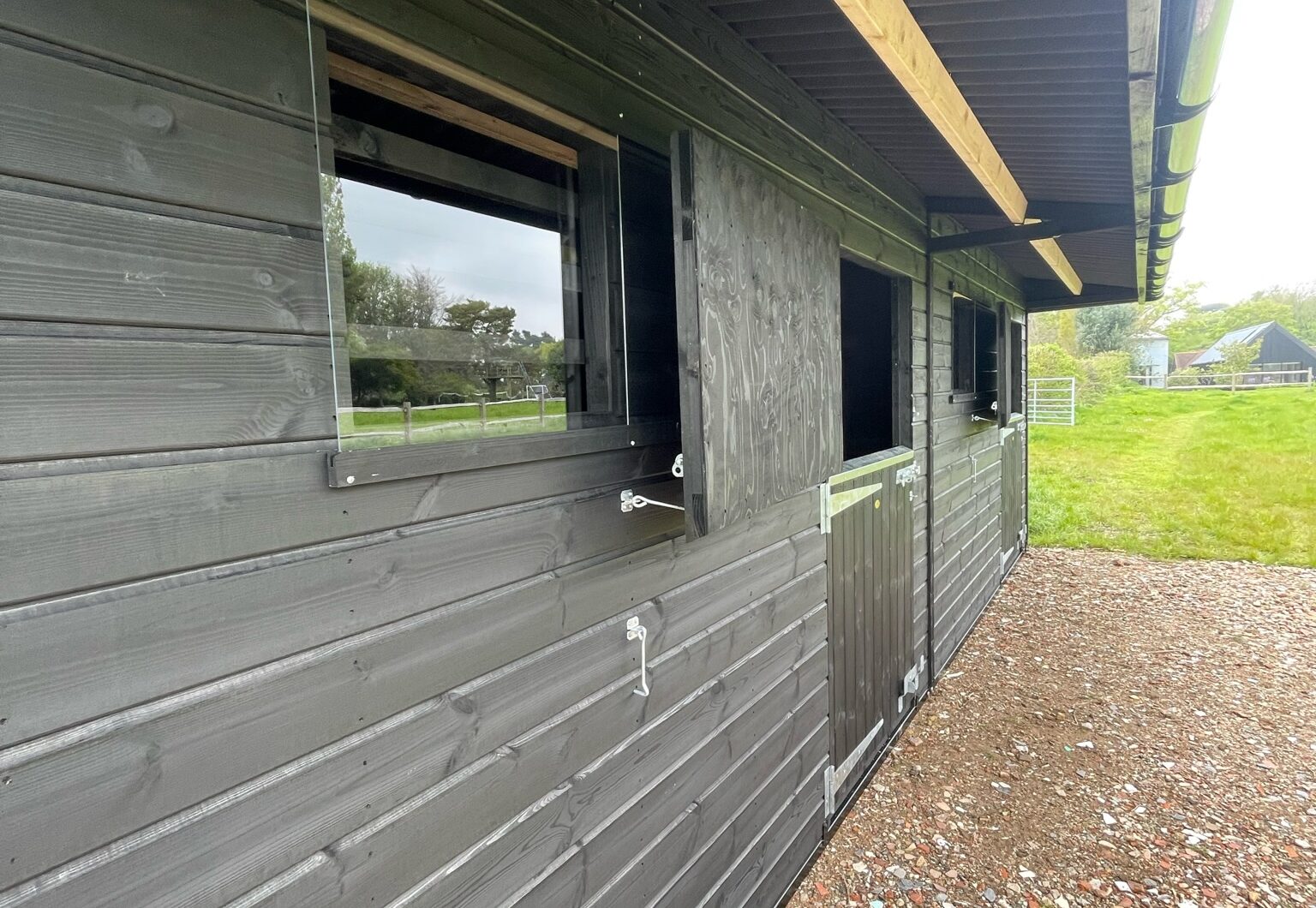 Double mobile stable painted black closeup of sliding perspex window