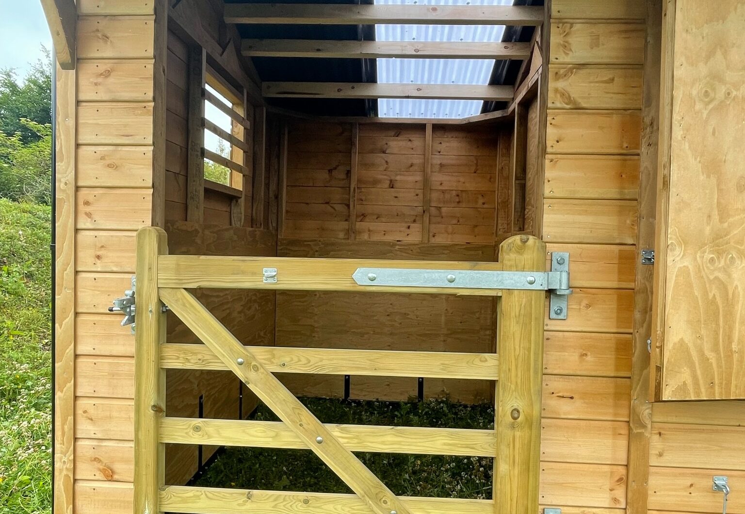 Dinkey donkey stable in paddock, close up of shelter area with wooden gate