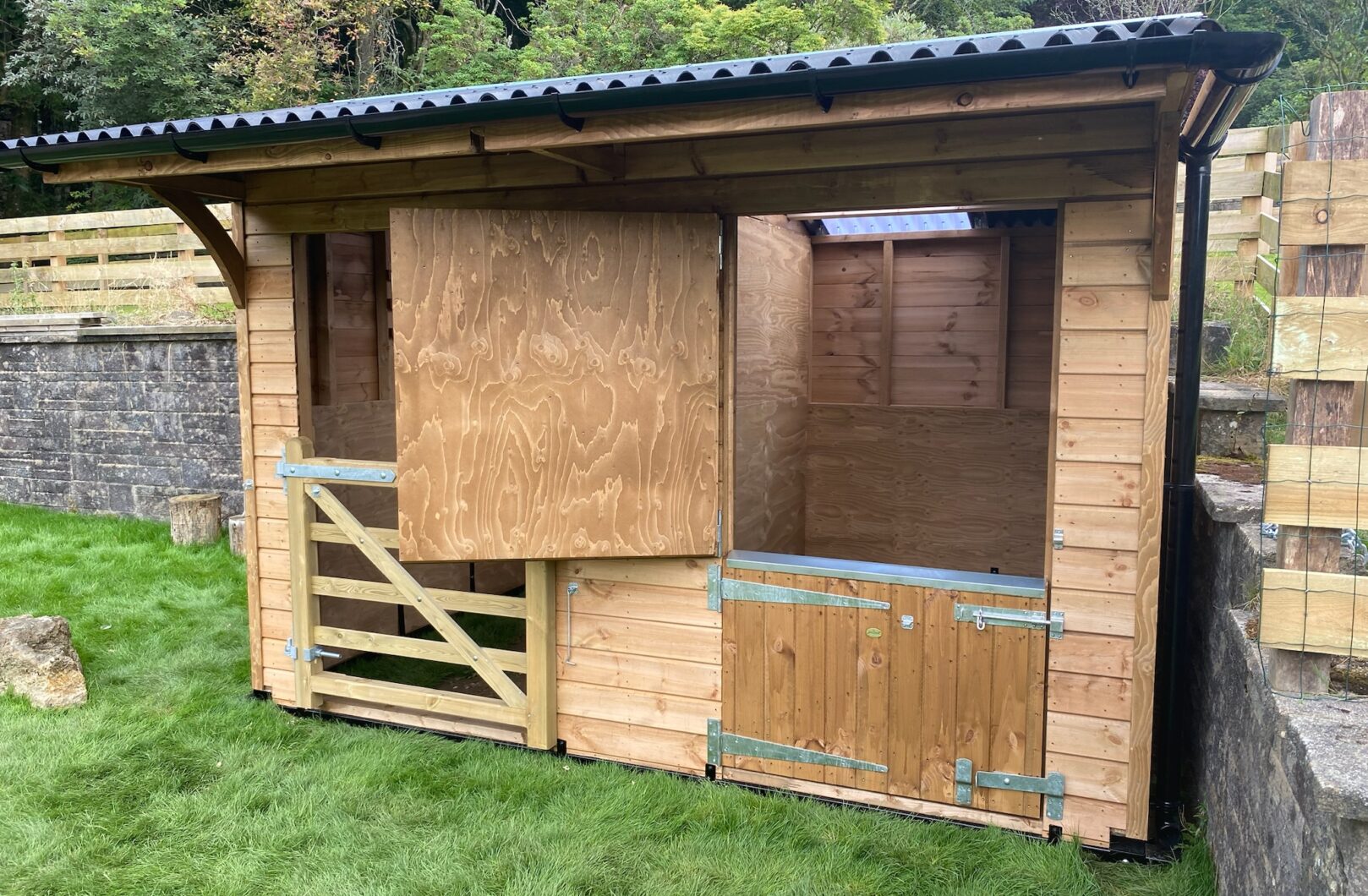 Dinkey donkey stable and shelter in paddock against retaining wall, right view