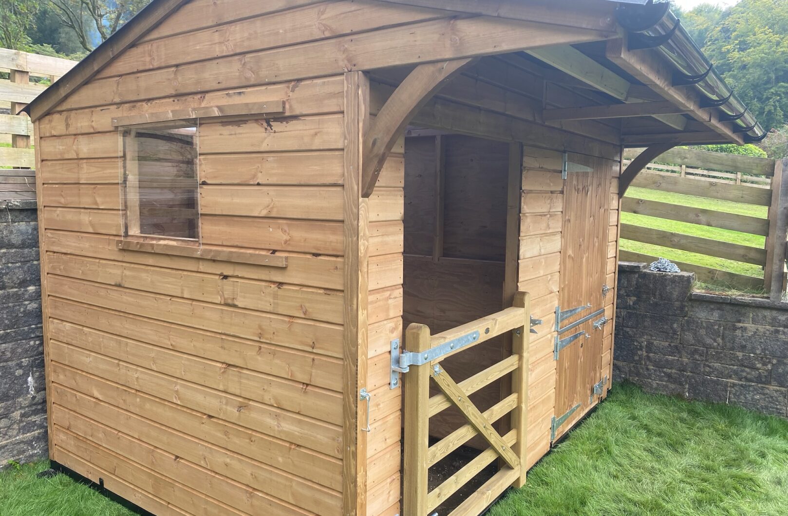 Dinkey donkey stable and shelter in paddock against retaining wall, left angle