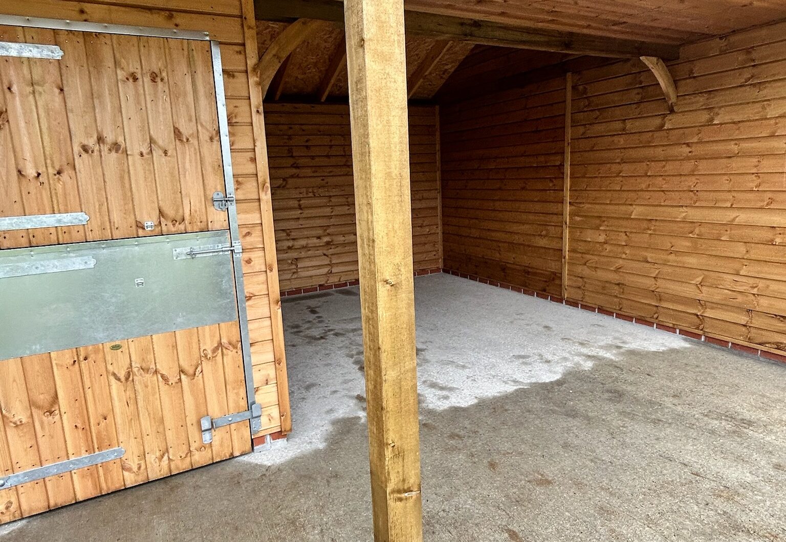 Support post with curved angle brace and covered walkway