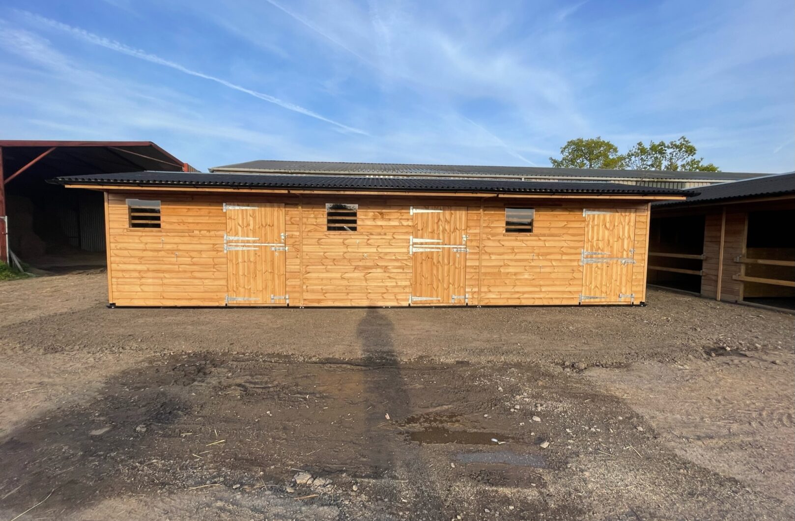 Front on view of a triple mobile stable in courtyard