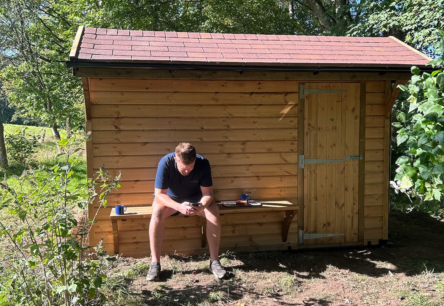 Mobile Sauna Shell with craftsman sitting on bench
