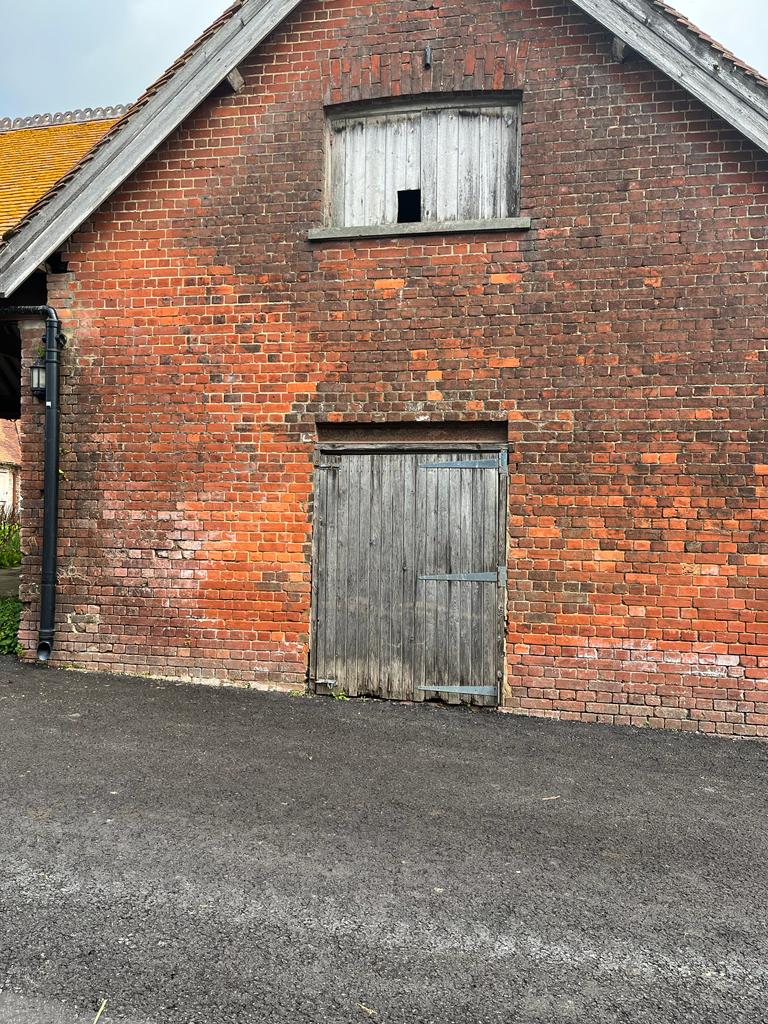 Old Prime Stables workshop, red brick, broken wooden slats over window